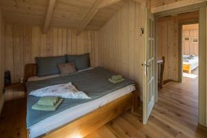 Una cama grande en una habitación de madera con suelos de madera. en Apartmán Nežichov 2 U Polocka, en Toužim