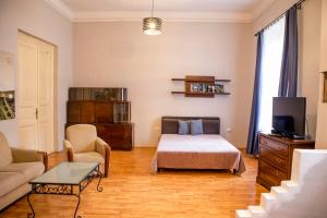 ブダペストにあるLinden Apartmentのベッドルーム(ベッド1台、ソファ、テレビ付)