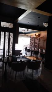 uma sala de jantar com mesas e cadeiras e uma janela em Hotel Greenoz em Jaipur