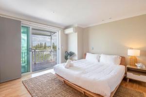Un dormitorio con una cama grande y una ventana grande. en Surf & Sand - Oceanstays, en Yamba