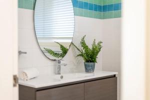 un baño con lavabo y espejo en Surf & Sand - Oceanstays, en Yamba 17 fotos más