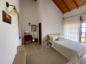 a white bedroom with a bed and a window at Misty Hills Villa - Kandy in Kandy