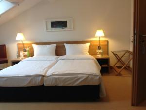 a bedroom with a large bed with white sheets and pillows at Sapia Hotel St. Fridolin in Bad Säckingen