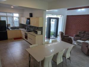 The Anchorage Villa - Negombo في نيجومبو: مطبخ وغرفة معيشة مع طاولة وكراسي بيضاء