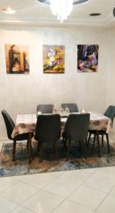 a dining room with a table and chairs and paintings at مسكن الراحة in Tafza