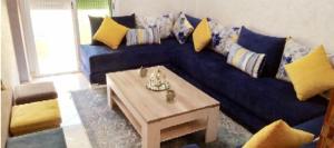 Sofá azul en la sala de estar con mesa de centro en مسكن الراحة, en Tafza