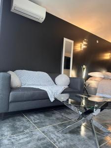 ein Wohnzimmer mit einem Sofa und einem Glastisch in der Unterkunft Studio chic jacuzzi in Portet-sur-Garonne