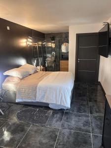 um quarto com uma cama e uma parede preta em Studio chic jacuzzi em Portet-sur-Garonne