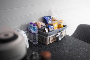 una cesta de comida y agua embotellada en un mostrador en Endrick Escape - Luxury Glamping, 