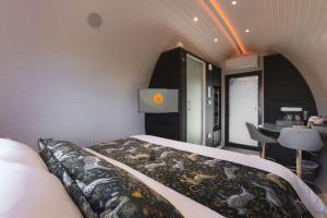 a small bedroom with a bed and a table at Endrick Escape - Luxury Glamping 