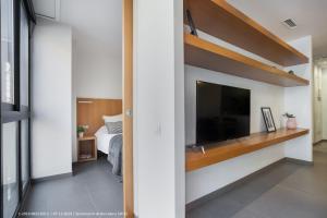 a bedroom with a large flat screen tv and a bed at Flateli Navas D02 in Barcelona