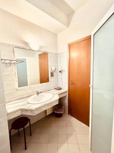 a bathroom with a sink and a mirror and a stool at Albergo Ristorante Belsito in Fiuggi