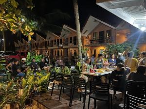 un grupo de personas sentadas en mesas en un restaurante en LANGOJON JIANJOY BEACH RESORT en Libertad