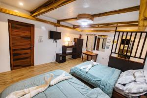 two beds in a room with towel animals on them at LANGOJON JIANJOY BEACH RESORT in Libertad