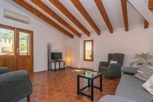 a living room with a couch and chairs and a tv at Ca'n Mayol (Banyeta) in Fornalutx