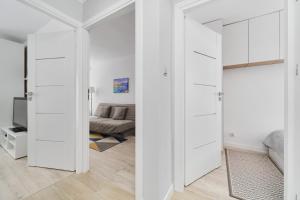 a room with white doors and a couch at Charming Family Apartment in Wroclaw by Renters in Wrocław