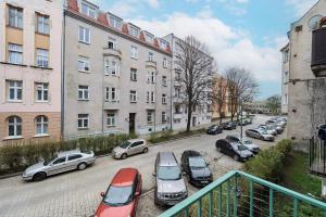 a parking lot with cars parked in front of buildings at Charming Family Apartment in Wroclaw by Renters in Wrocław