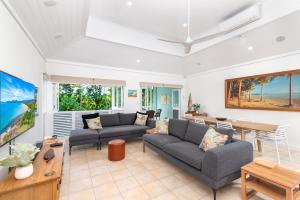uma sala de estar com dois sofás e uma mesa em Seascape Holidays Villas on Murphy Street em Port Douglas