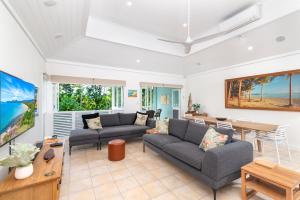 ein Wohnzimmer mit 2 Sofas und einem Tisch in der Unterkunft Seascape Holidays Villas on Murphy Street in Port Douglas