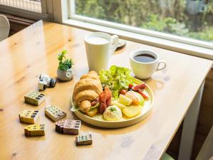 a table with a plate of food and a cup of coffee at 碧水山居湖畔民宿 in Yuchi