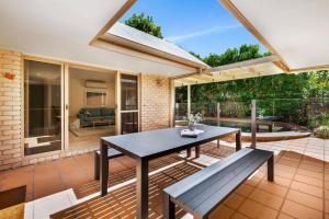 a patio with a table and a bench at Witta Circle 24 in Noosa Heads