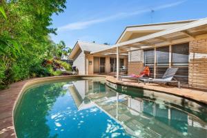 a swimming pool in front of a house at Witta Circle 24 in Noosa Heads