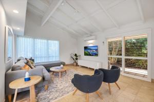 a living room with a couch and a table and chairs at Witta Circle 24 in Noosa Heads