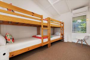 Un dormitorio con dos literas y una silla. en Witta Circle 24, en Noosa Heads