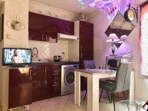 a kitchen with a table and a tv in it at Le carre des Musiciens CENTRE CANNES MER in Cannes