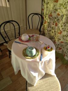 una mesa con mantel blanco y set de té en Sa Pruninca en Villanova Monteleone