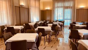 une salle remplie de tables et de chaises avec des tables blanches et des chaises dans l'établissement Albergo Ristorante Belsito, à Fiuggi