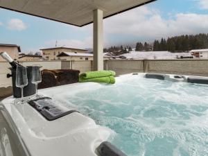 a jacuzzi tub with a green towel in it at Ledermaier Loft & Lodge`s eU in Achenkirch