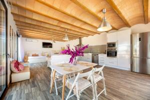 a kitchen and living room with a table and chairs at Can Maruna in Sant Joan de Labritja