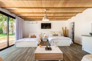 two beds in a room with wood ceilings at Can Maruna in Sant Joan de Labritja