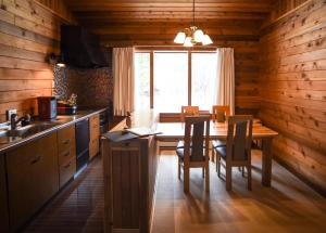 a kitchen with a table and chairs and a window at Woodpecker Chalet in Hakuba