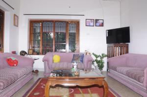 a living room with two couches and a coffee table at Misty Retreat (Pragati House) in Madikeri