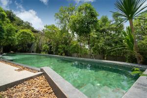 una piscina en un patio con árboles en Natural Park Studio B24 with Magical Forest View, 5 Min to Kamala Beach & Phuket FantaSea en Kamala Beach