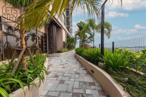 une passerelle avec des palmiers et un bâtiment dans l'établissement Bali Premier Suites Melaka, à Malacca