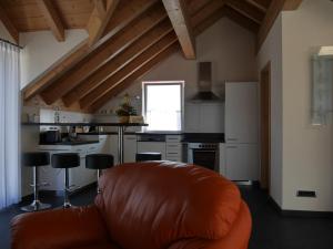 ein Wohnzimmer mit einer orangefarbenen Couch in einer Küche in der Unterkunft Schöne Loftwohnung ca. 9km vom Bodensee entfernt in Stockach