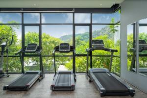 un gimnasio con 3 cintas de correr frente a una gran ventana en Natural Park Studio B24 with Magical Forest View, 5 Min to Kamala Beach & Phuket FantaSea, en Kamala Beach