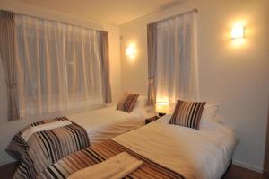 duas camas num quarto de hotel com uma janela em Cat's Villa Hakuba 1- Vacation STAY 82191 em Hakuba