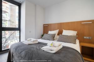 a bedroom with a large bed with towels on it at Flateli Navas A01 in Barcelona