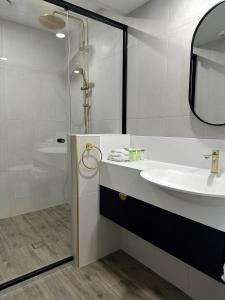 a white bathroom with a sink and a shower at The Shamrock Hotel in Toowoomba