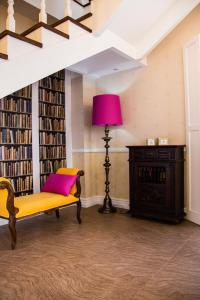 biblioteca con banco amarillo y lámpara rosa en Quinta das Candeias, en Candelária