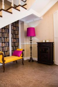 a library with a yellow bench and a pink lamp at Quinta das Candeias in Candelária