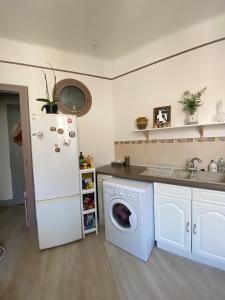 a kitchen with a white refrigerator and a washing machine at Logement hyper centre et près de la plage 1er étage in Biarritz