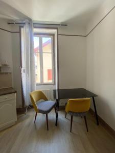 a dining room with a table and two chairs at Logement hyper centre et près de la plage 1er étage in Biarritz