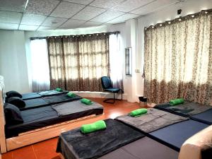 ein Zimmer mit 3 Betten und einem Stuhl darin in der Unterkunft OYO HOME 90768 Flo Inn Motel in Tawau
