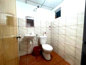 a bathroom with a toilet and a sink at OYO HOME 90768 Flo Inn Motel in Tawau