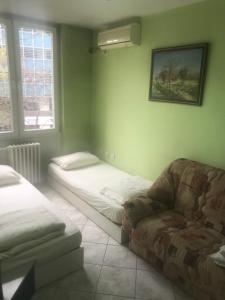 een slaapkamer met een bed, een bank en een raam bij Kalamaras Apartments in Skopje